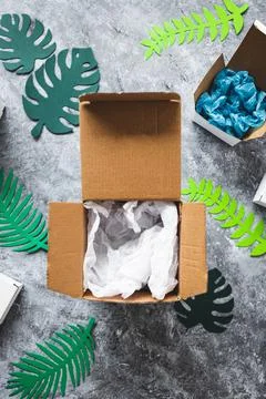 Online delivery parcel boxes with different shapes surrounded by green paper  Stock Photos