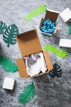 Online delivery parcel boxes with different shapes surrounded by green paper  스톡 사진