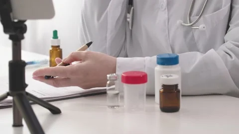 Online distant doctor appointment using video call, smartphone, tripod, bottles Stock Footage 202288800