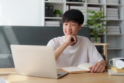 Online education, e-learning. Asian man in stylish casual clothes, studying Stock Photos