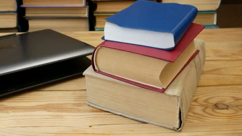 Online learning, studing and teaching concept, books pile and laptop, remote  Stock Footage 148770549