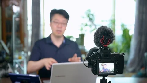 Online lecture concept. Asian middle-aged man giving online lectures at home. Stock Footage 127348490