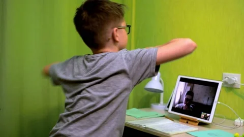 Online lesson. the boy spins in front of the tablet. dancing and enjoying Stock Footage 154895618