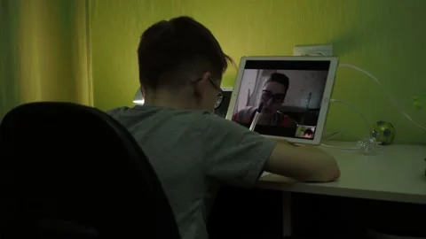 Online lesson. the boy writes in a notebook. the teacher tells the lesson topic Stock Footage 160202960