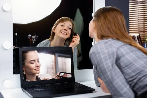 Online makeup tutorial. The make-up artist on the laptop screen, the student Stock-Fotos