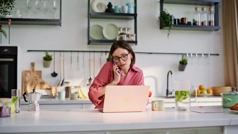 Online manager calling cellphone working laptop at kitchen home office closeup Stock Footage 335104721