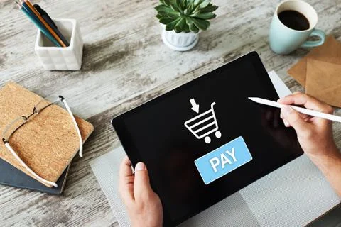 Online payment an e-commerce concept. Pay button on tablet screen. Stock Photos