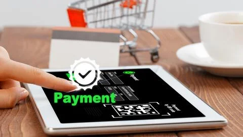 Online payment process on tablet with shopping cart and coffee cup at table in Stock Photos