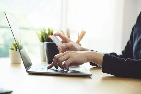 Online payment, Young Women's using computer and hands holding credit card for Stock Photos