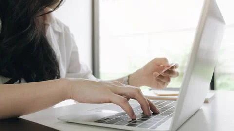 Online payment,Young woman's hands using credit card and computer laptop for Stock Photos