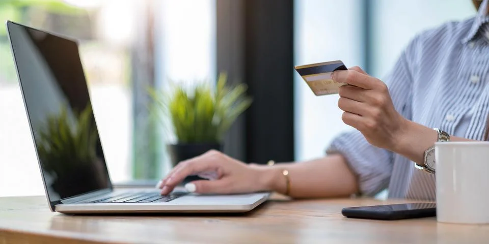 Online payment,Young woman's hands using computer and hand holding credit c.. Stock Photos