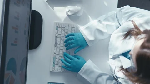 An online scientist enters data into the Internet at his workplace in his Stock Footage 259998539