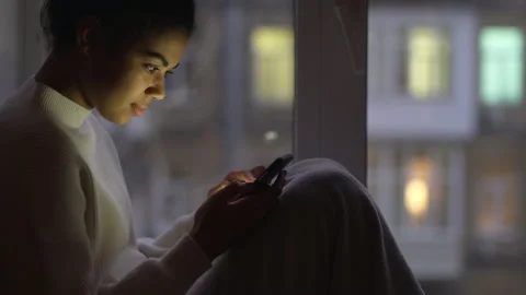 Online. Side view of young mixed race woman using smartphone, scrolling the Stock Footage 146203814