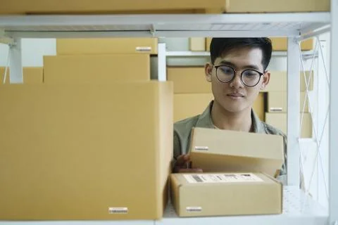 Online store owner checking orders for packaged product. Stock Photos