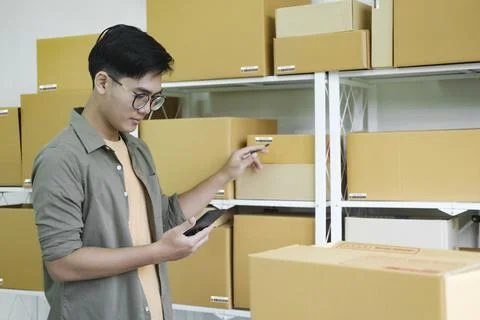Online store owner checking orders for packaged product. Stock Photos