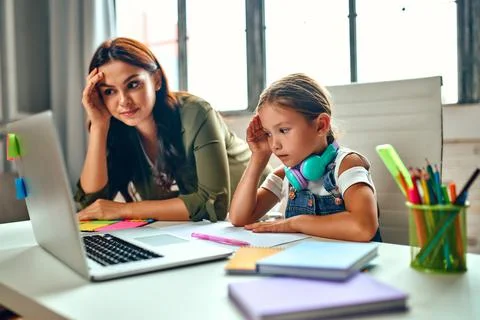 Online training. Very difficult lessons. Schoolgirl with her mother listen to Stock-Fotos