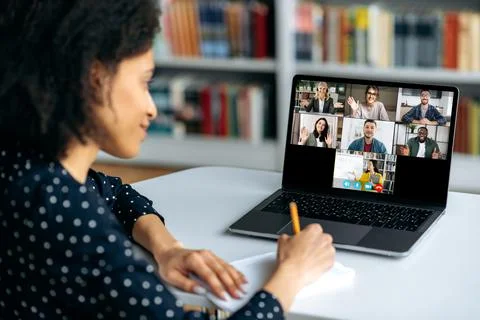 Online training by video conference. African American girl student makes notes Stock Photos