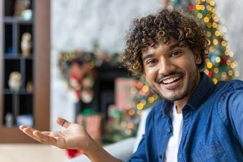 Online video call, remote conversation for Christmas, man uses app on phone to Stock Photos
