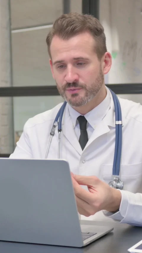 Online Video Chat by Middle Aged Doctor in Clinic, vertical video Stock Footage 324795330