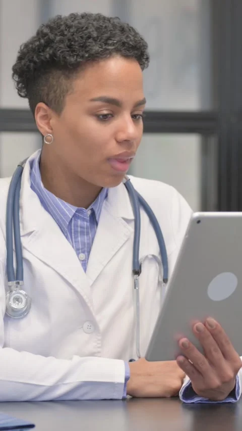Online Video Chat on Tablet by Mixed Race Female Doctor, vertical video Stock-Footage 324684394