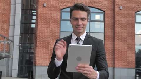 Online Video Chat on Tablet by Walking Businessman on Street Stock Footage 94851941