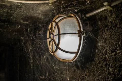 Only lightsource in abandoned cave system woven by spiders and a slight sound 库存照片