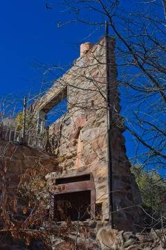 The only thing left of this old stone house is one wall and a fireplace. Stock Photos