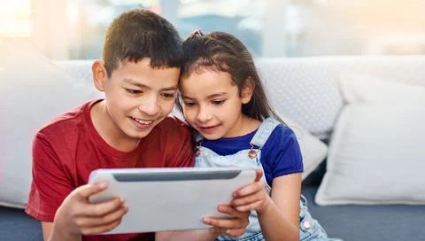 This is the only time they get along. two young children using a digital tablet Stock Photos