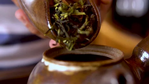 Oolong chinese tea, dried leaves in cha he close-up. Man pouring tea into a Stock Footage 140715429