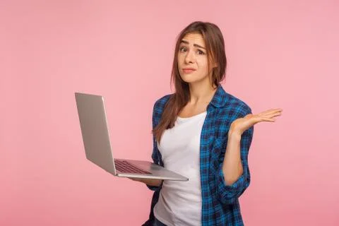 Oops, it doesn't work! Frustrated girl in checkered shirt holding laptop and  Foto stock