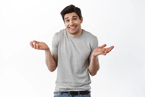 Oops sorry, my mistake. Man shrugging and smiling awkward, feeling guilty Stock Photos
