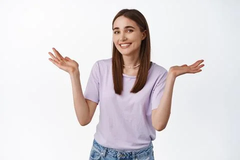 Oops sorry silly mistake. Smiling girl shrugging shoulders with awkward grin Stock Photos