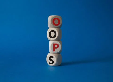 Oops symbol. Concept word Oops on wooden cubes. Beautiful blue background. .. Stock Photos