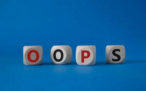 Oops symbol. Concept word Oops on wooden cubes. Beautiful blue background. .. Stock Photos
