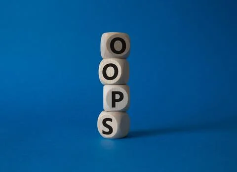 Oops symbol. Concept word Oops on wooden cubes. Beautiful blue background. .. Stock Photos
