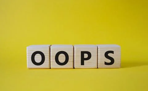 Oops symbol. Concept word Oops on wooden cubes. Beautiful yellow background.. Stock Photos