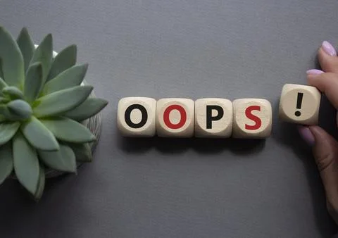 Oops symbol. Concept word Oops on wooden cubes. Businessman hand. Beautiful.. Stock Photos