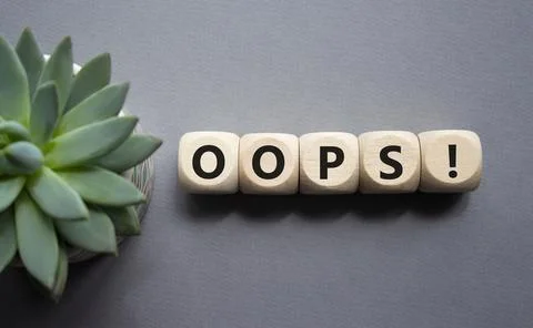 Oops symbol. Concept word Oops on wooden cubes. Beautiful grey background w.. Stock Photos