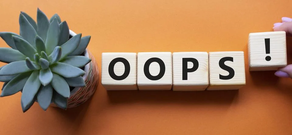 Oops symbol. Concept word Oops on wooden cubes. Businessman hand. Beautiful.. Stock Photos