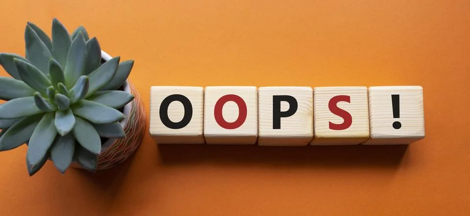 Oops symbol. Concept word Oops on wooden cubes. Beautiful orange background.. Foto stock