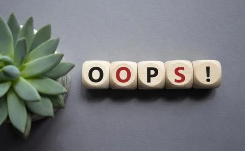 Oops symbol. Concept word Oops on wooden cubes. Beautiful grey background w.. Stock Photos