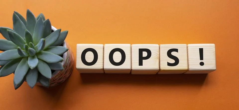 Oops symbol. Concept word Oops on wooden cubes. Beautiful orange background.. Foto stock