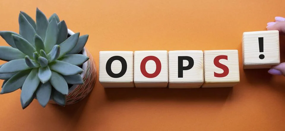 Oops symbol. Concept word Oops on wooden cubes. Businessman hand. Beautiful.. Stock Photos