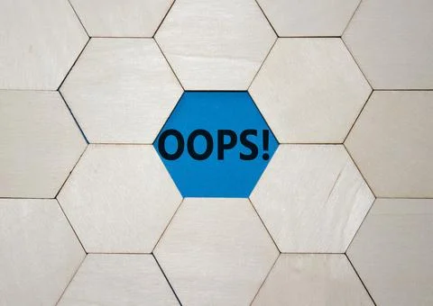 Oops symbol. Concept word Oops on wooden comb puzzle. Beautiful blue backgr.. Foto stock