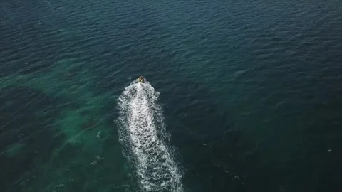 Op-down aerial drone shot of a small motorboat speeding across the deep Video stock 345003335