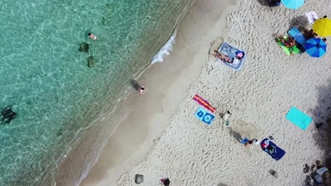 Op down view of sand beach. People swimming and having fun on beach Video stock 139352191