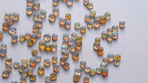 Opals gemstone from Ethiopia rotates on light background. White fire opals 库存影片 121574152