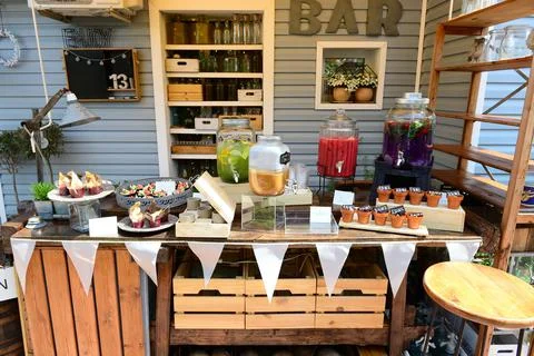 An open-air bar stand with refreshing colorful drinks and dessert assortments Stock Photos