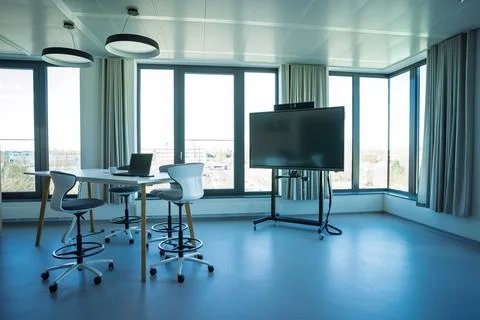 Open-air collaborative meeting space with tables chairs laptop Stockfoto's
