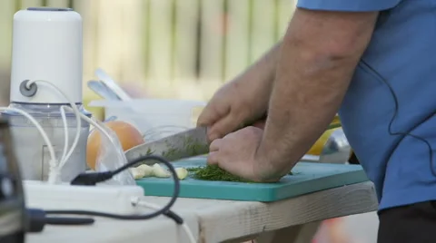 Open air kitchen demonstration,man chopping herbs in daylight Stock Footage 54464788